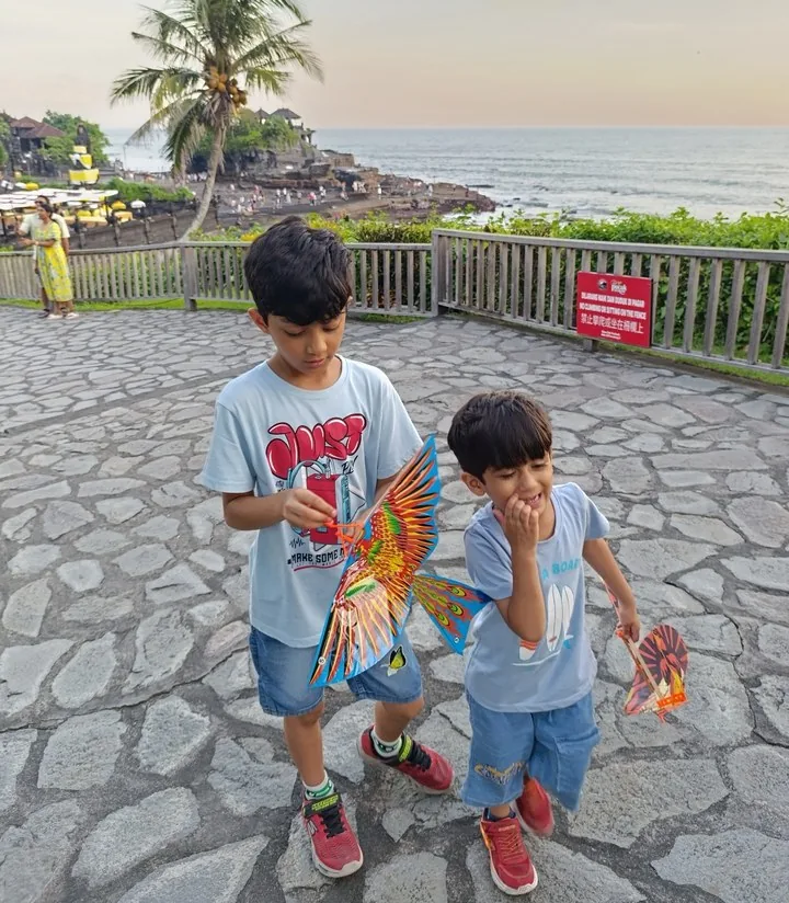A photograph of two children on a seafront path